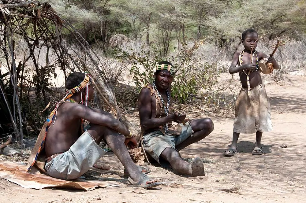 Hadza hunters walking through Lake Eyasi bush during an early morning traditional hunting expedition together.