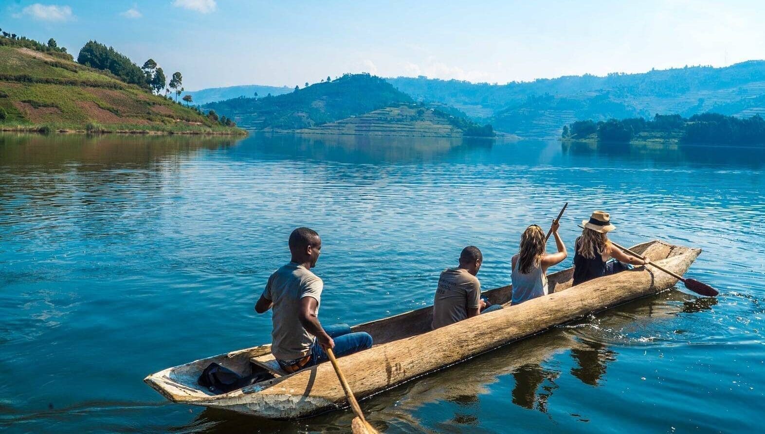 Scenic Lake Bunyonyi shoreline with travelers heading toward Bwindi gorilla trekking adventure.