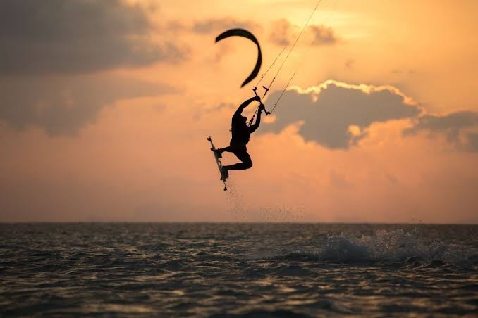 White sand beach lined with colorful kites above turquoise Indian Ocean waters