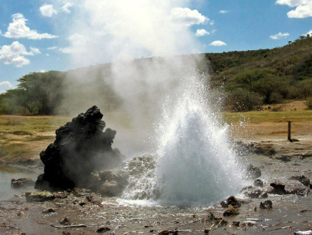 Natural geothermal springs surrounded by rugged volcanic rocks beneath clear northern Kenya skies