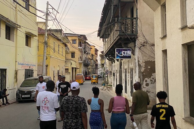 Tourists walking a narrow coral street in Mombasa Old Town, Kenya.