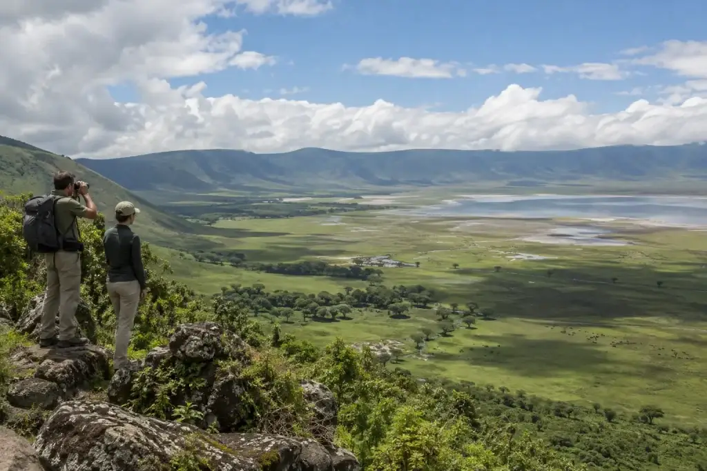 Wide green crater panorama with clouds and distant lake